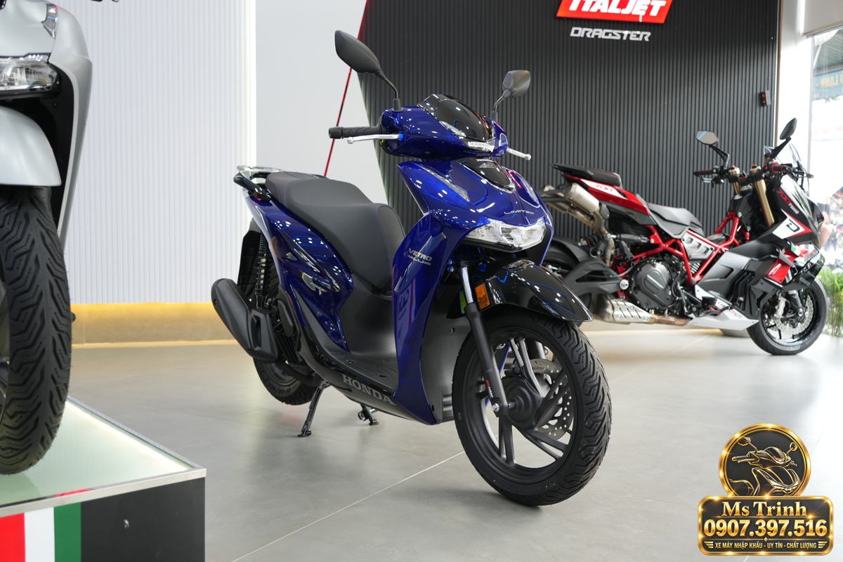 SH150i Vetro Blue Sapphire 2027 nhìn từ góc nghiêng trong showroom Honda SH150i Vetro Blue Sapphire 2027 nhìn góc nghiêng trước với thân xe xanh bán trong suốt